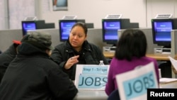  FILE - A case worker offers advice to job seekers at a San Francisco employment center.