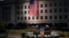 The podium awaits the arrival of President Donald Trump as a U.S. flag is unfurled at the Pentagon on the 16th anniversary of the September 11th attacks, Sept. 11, 2017. 