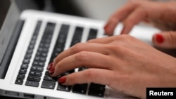 A person types on a laptop computer in Manhattan, New York City
