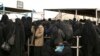In this March 31, 2019, photo, women line up for aid supplies at Al-Hol camp in Hassakeh province, Syria. 