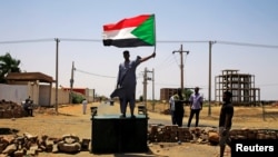 Symbole de la résistance de la contestation, un manifestant, drapeau national en main, défie les forces de l'ordre, à Khartoum, le 5 juin 2019.
