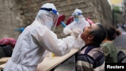 Seorang pekerja medis melakukan tes asam nukleat gratis di provinsi Xinjiang, China,19 Juli 2020. (Foto: Reuters)