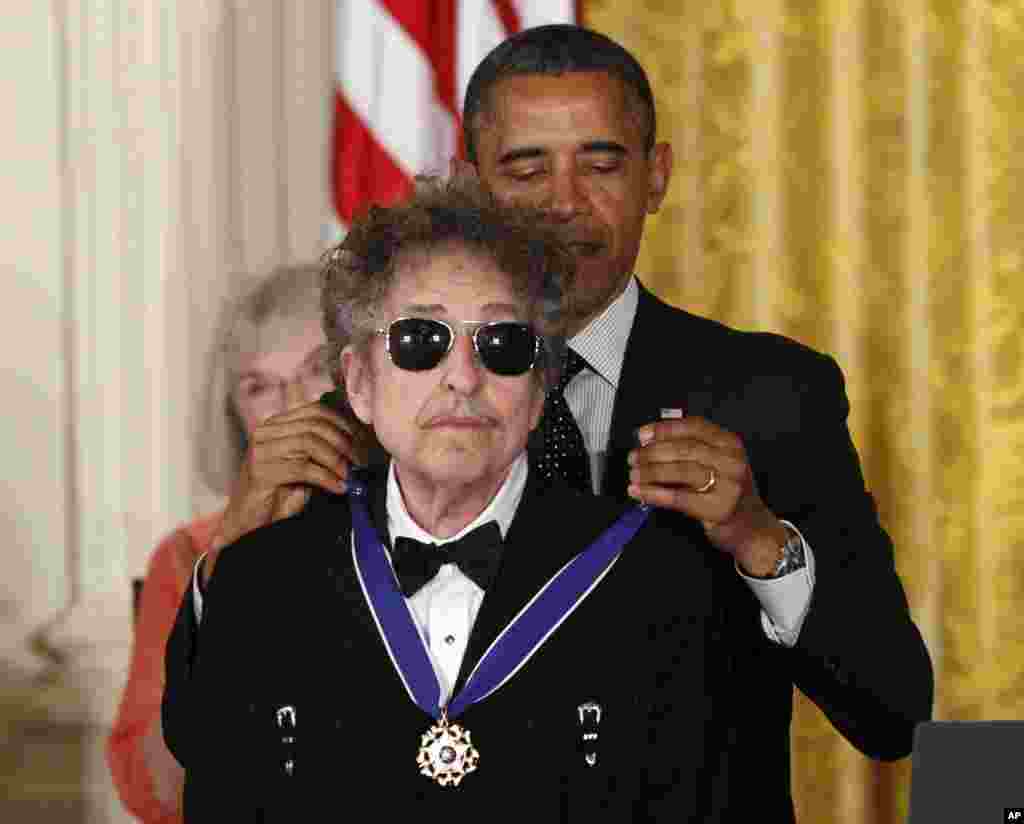 Presiden AS Barack Obama mengalungkan Medali Kemerdekaan kepada legenda rock Bob Dylan dalam upacara di Gedung Putih, Washington, Mei 2012. (AP/Charles Dharapak)