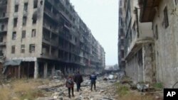 Des habitants marchent dans les ruines de la ville d'Alep, Syrie, le 13décembre 2016.