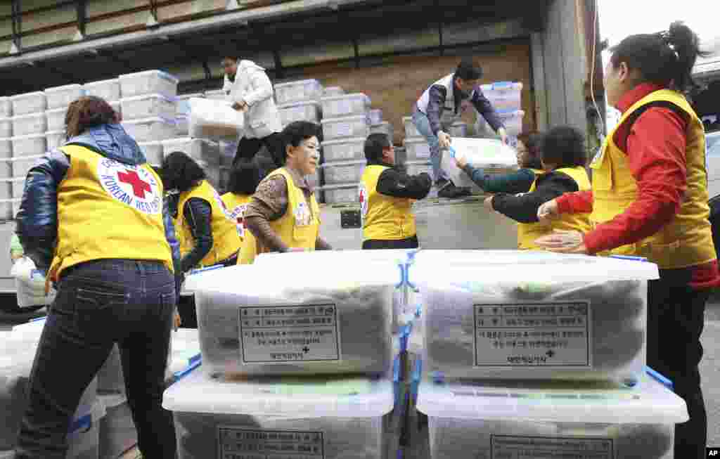 Members of the South Korean Red Cross unload emergency relief packages from a truck at Incheon Airport Cargo Terminal, Incheon, South Korea, Nov. 14, 2013.