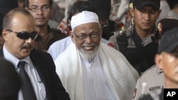 Radical cleric Abu Bakar Bashir, center, leaves the court after the judges delivered his sentence during his trial at a district court In Jakarta, Indonesia, June 16, 2011