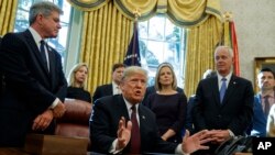 President Donald Trump answers a reporters question about the investigation of special counsel Robert Mueller during a signing ceremony of the "Cybersecurity and Infrastructure Security Agency Act," in the Oval Office of the White House, Nov. 16, 2018, in Washington.