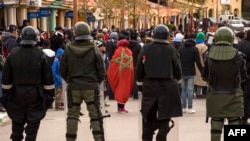 oliciers anti-émeutes face aux manifestants après les funérailles de deux frères morts dans l’effondrement d'une mine de charbon abandonnée à Jerada, le 27 décembre 2017.
