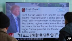 FILE - People watch a TV news program showing the Twitter post of U.S. President Donald Trump in Seoul, South Korea, Jan. 3, 2018. Trump boasted that he has a bigger and more powerful "nuclear button" than North Korean leader Kim Jong Un. 