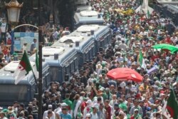 Algerian riot policemen stand guard as protesters gather during a weekly demonstration coinciding with the Algerian independence day in Algiers, July 5, 2019.