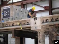 Graduate students at the University of Nevada, Reno's College of Engineering inspect a bridge model for damage after tests on a giant shake table intended to simulate violent earthquake activity at the school's new Earthquake Engineering Building in Reno, Nevada.
