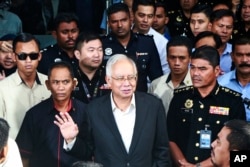 FILE - Former Malaysian Prime Minister Najib Razak, center, speaks to media as he leaves the Malaysian Anti-Corruption Commission (MACC) Office in Putrajaya, Malaysia, May 24, 2018.
