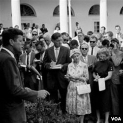 Presiden John F. Kennedy (kiri) memberi ucapan selamat jalan kepada rombongan sukarelawan Peace Corps pertama di Gedung Putih, 28 Agustus 1961.