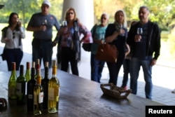 People attend a wine tasting event at a vineyard near Santiago, Chile, April 6, 2017.