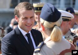 French President Emmanuel Macron shakes hands with French military personnel at the naval base during his second day of visit in Abu Dhabi, United Arab Emirates, Thursday, Nov. 9, 2017.