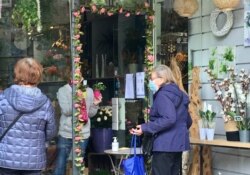 A Paris flower store, flouting French lockdown rules, sells lily of the valley flowers for May Day. (Lisa Bryant/VOA)