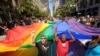 Mark Wilson, right, helps carry a rainbow flag during San Francisco's 42nd annual Gay Pride parade on Sunday, June 24, 2012. (AP Photo/Noah Berger)