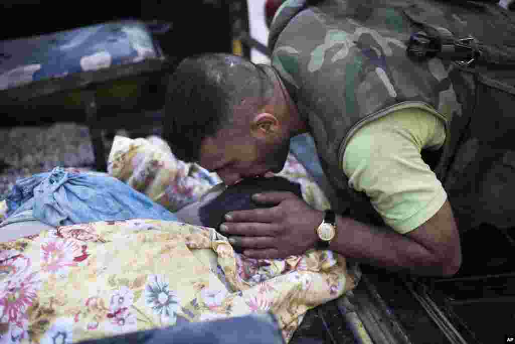 A Free Syrian Army fighter kisses the the head of his comrade, killed by a tank blast, in Aleppo, Syria, Sept. 26, 2012.