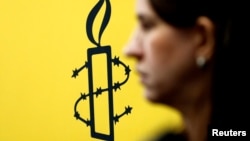 La militante des droits des femmes, Luisa Kislinger, devant le logo d'Amnesty International à Caracas au Venezuela le 20 février 2019.