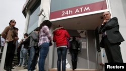 Antrian panjang warga di luar ATM salah satu cabang bank Laiki di Nicosia (21/3). Para pemimpin Siprus terus mengupayakan pengumpulan dana sebesar $7,5 Miliar sebelum batas waktu yang ditetapkan Uni Eropa, Senin (25/3).