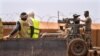 Les commandos de la force française Barkhane montent une mitrailleuse sur une camionnette camouflée alors que des travailleurs maliens passent avant de partir en mission depuis leur base de Gao, au Mali, le undi 7 juin 2021.