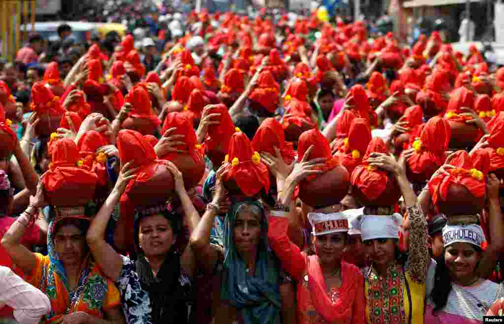Devotees carry clay water pots as they take part in a procession marking the end of Jhulelal Chaliha, a 40-day-long fasting festival of the Sindhi community, in Ahmedabad, India.