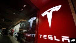 Sebuah tanda berlogo perusahaan ditampilkan di luar toko Tesla di Cherry Creek Mall di Denver, 9 Februari 2019. (Foto: AP/David Zalubowski)