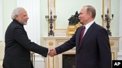 Presiden Rusia, Vladimir Putin (kanan) berjabat tangan dengan PM India Narendra Modi dalam pembicaraan di Kremlin, Rabu (23/12). 