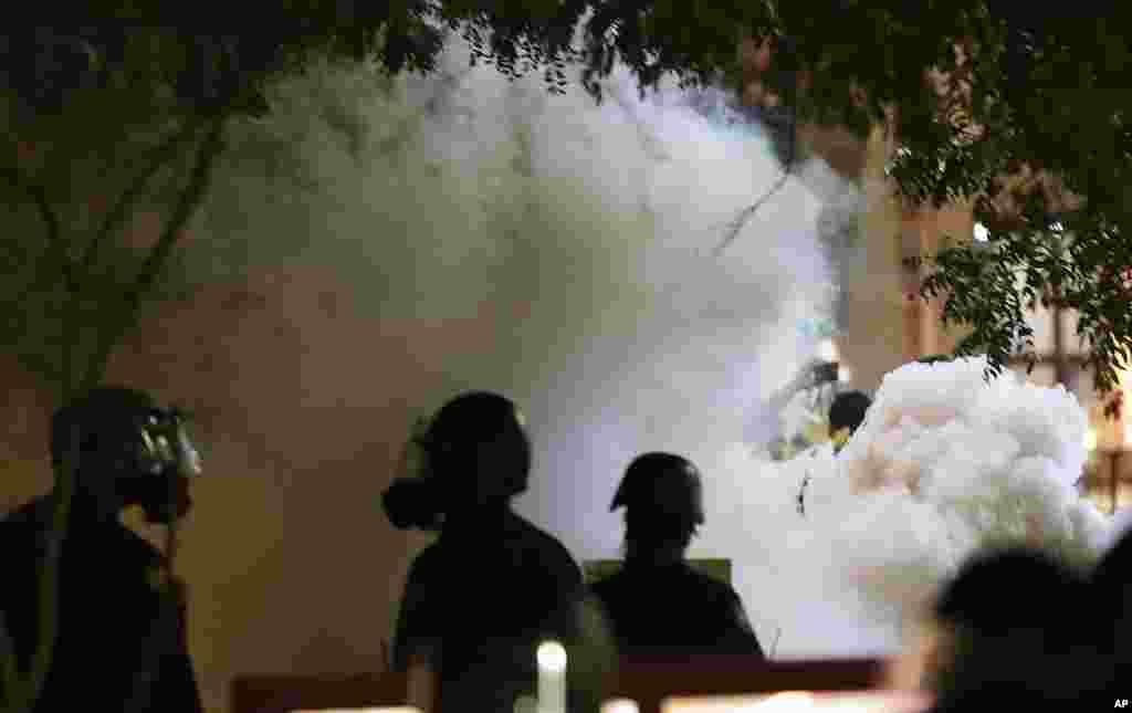 Smoke billows after Phoenix police used tear gas outside the Phoenix Convention Center, Aug. 22, 2017, in Phoenix. Protests were held against President Donald Trump as he hosted a rally inside the convention center.
