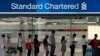 Antrian nasabah di luar kantor cabang Standard Chartered Bank di pusat bisnis Singapura sebelum jam layanan bank buka, 23 Januari 2014. (Foto: dok).