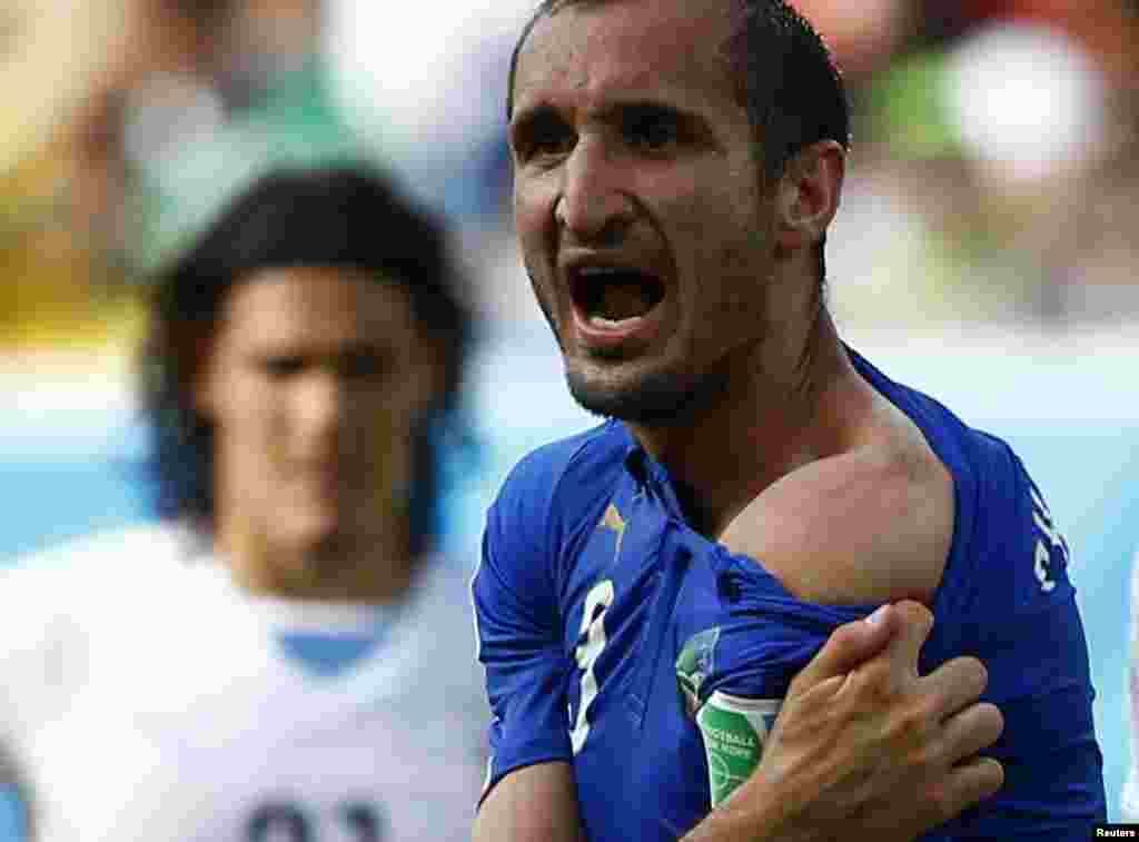 Italy's Giorgio Chiellini shows his shoulder, claiming he was bitten by Uruguay's Luis Suarez, during their 2014 World Cup Group D soccer match at Dunas arena in Natal, Brazil, June 24, 2014.