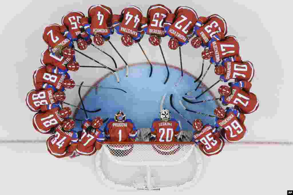 The Russian women's ice hockey team huddles around the net before their game against Germany, Sochi, Russia, Feb. 9, 2014.