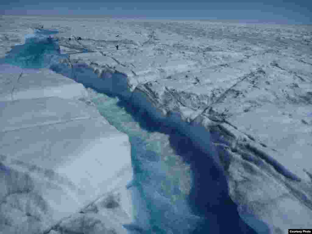 Greenland&rsquo;s supraglacial rivers are large and swift. Note researchers on right for scale! (UCLA/Laurence C. Smith)
