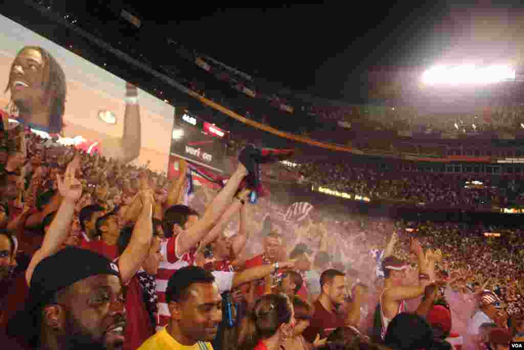 USA fans celebrate after Herculez Gomez scores in the 45th minute, reducing Brazil&#39;s lead to 2-1. VOA/M. Lipin