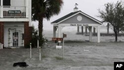 Angin kencang dan air menggenangi gedung-gedung di kawasan Front Street, pusat kota Swansboro, North Carolina, saat badai Florence menghantam wilayah tersebut, 14 September 2018. 
