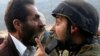 Seorang pria Palestina adu mulut dengan tentara Israel saat penutupan sekolah Palestina dekat Nablus, Tepi Barat yang diduduki Israel, Senin (15/10). 