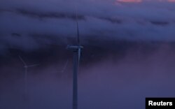 FILE - Wind turbines are surrounded by fog at a wind farm in the mountains of Galicia region, near Vilalba, Spain March 20, 2024. (REUTERS/Nacho Doce)