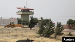 FILE - Turkish soldiers stand on a watch tower at the Atmeh crossing on the Syrian-Turkish border, as seen from the Syrian side, in Idlib governorate, Syria, May 31, 2019. 