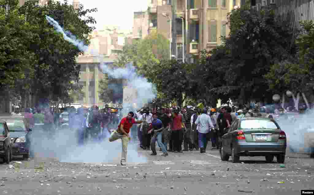 A supporter of ousted President Mohamed Morsi throws a tear gas canister back towards the police during clashes in central Cairo, August 13, 2013.