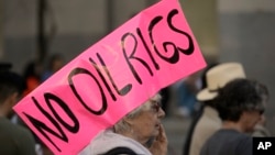A protester against oil drilling off the California coast joins a rally at the state Capitol before marching to a hearing of the U.S. Bureau of Ocean Energy Management, Feb. 8, 2018, in Sacramento, Calif. It's the only public hearing in California on a Trump administration plan to propose six sales of drilling rights off the state's coast.