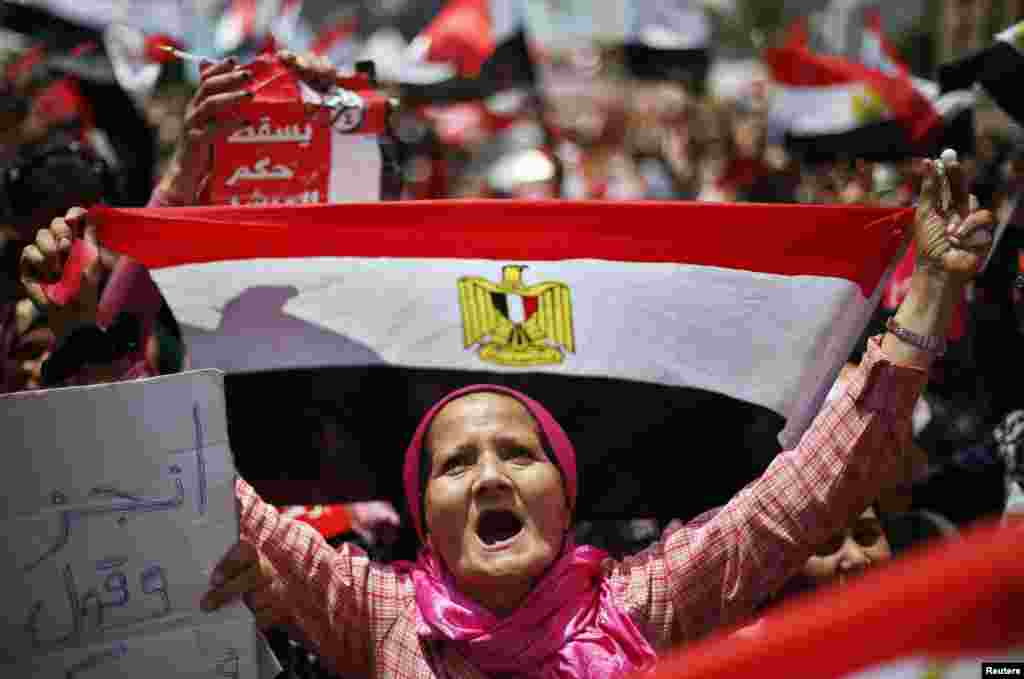 Seorang pengunjuk rasa yang menentang Presiden Mesir Mohamed Morsi, memegang bendera Mesir selama protes menuntut Morsi untuk mengundurkan diri di Lapangan Tahrir, Kairo.