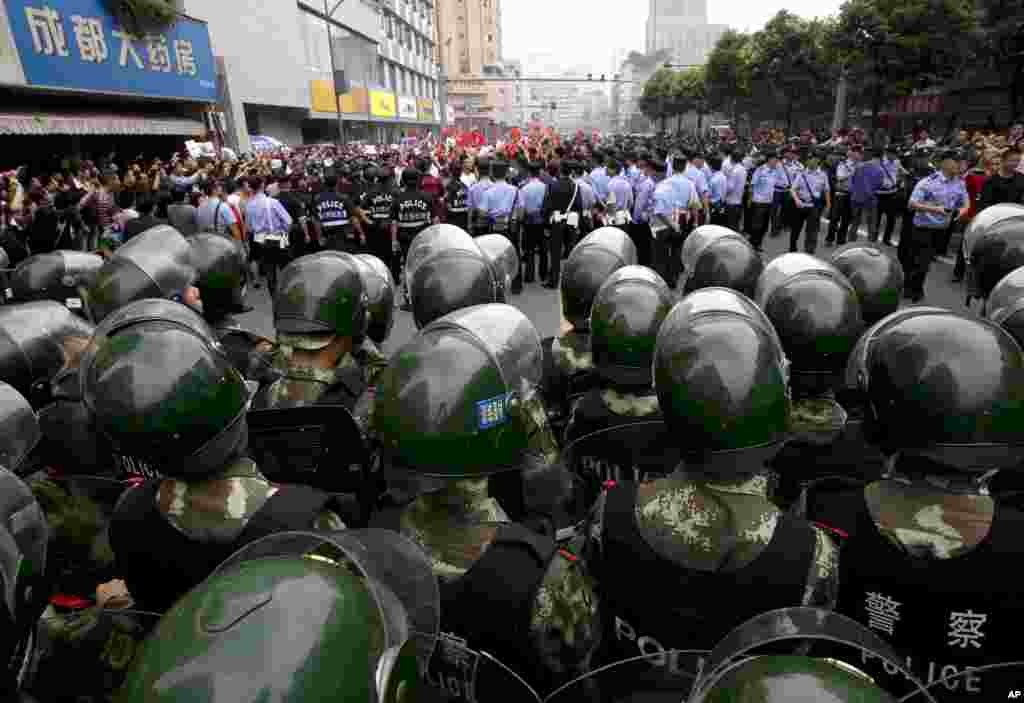 Demonstrators are surrounded by uniformed policemen and paramilitary policemen during a protest against Japan in Chengdu, in southwest China's Sichuan province, September 18, 2012.