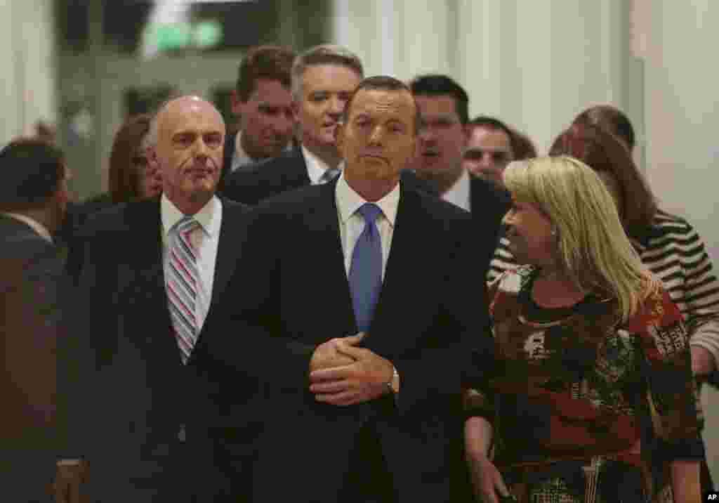 Perdana Menteri Australia Tony Abbott (tengah) meninggalkan pertemuan Partai Liberal Australia dimana ia kehilangan kepemimpinan partai di Gedung Parlemen di Canberra (14/9). (AP/Andrew Taylor)