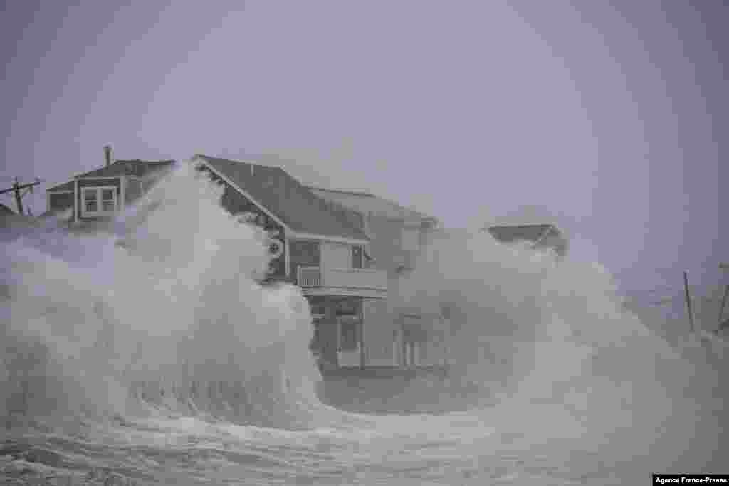 Waves crash over oceanfront homes during a nor&rsquo;easter in Scituate, Massachusetts, Jan. 29, 2022.
