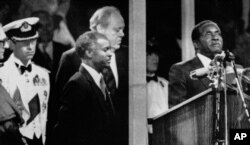 FILE: During the Independence celebrations, on April 18, 1980, Prime Minister Robert Mugabe takes the oath of allegiance to Zimbabwe in Highfields, Harare, Zimbabwe.