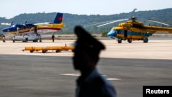 An officer stands guard near Vietnam aircraft before a mission to find the Malaysia Airlines flight MH370 that disappeared from radar screens Saturday, at Phu Quoc Airport on Phu Quoc Island, March 10, 2014.