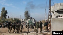 FILE - Iraqi rapid response forces gather during a fight with Islamic State militants in Intisar district of eastern Mosul, Iraq, Dec. 22, 2016. 