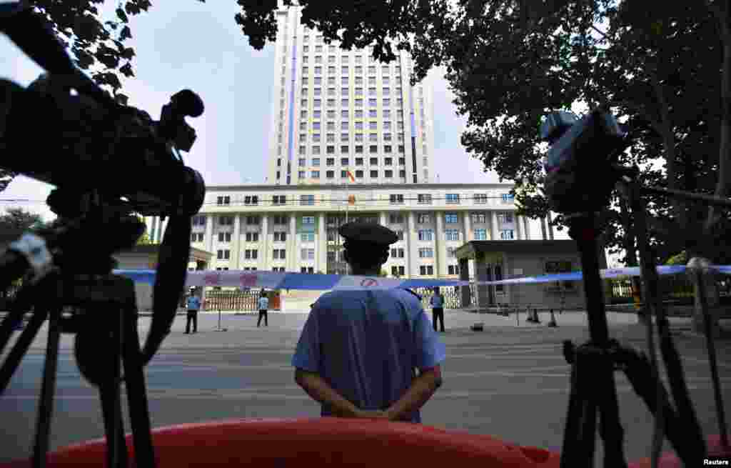 A policeman guards the entrance of the Jinan Intermediate People's Court in Jinan, Shandong province, August 26, 2013. 