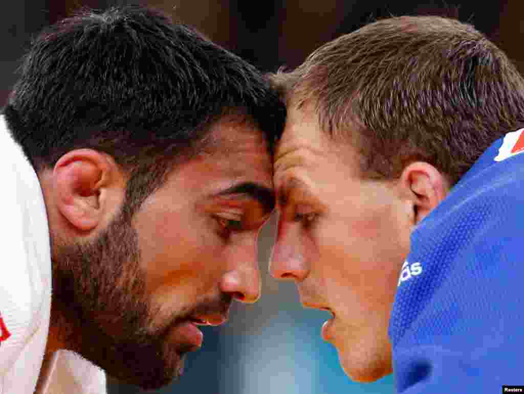 Greece's Ilias Iliadis fights with Lithuania's Karolis Bauza (blue) during their men's -90kg elimination round of 16 judo match.