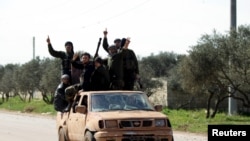 Kelompok pemberontak Suriah Ahrar al-Sham di mobil bak terbuka di barat laut kota Idlib, 26 Maret 2015. (Foto: dok.)